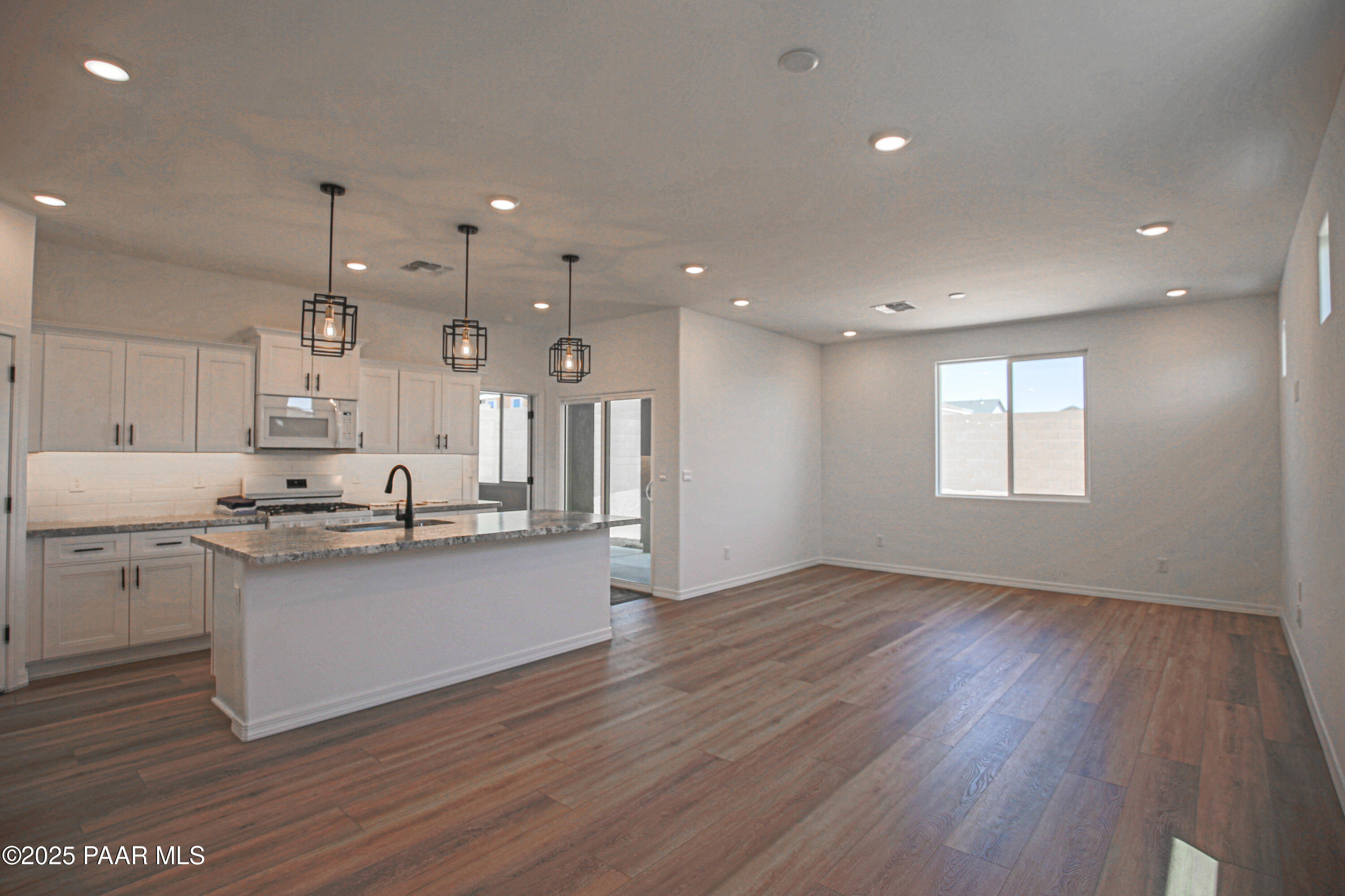 1224 Woodchute Road Prescott, AZ 86305 - Photo 6 of 43 a large kitchen with granite countertop a large counter top space a sink stainless steel appliances and cabinets