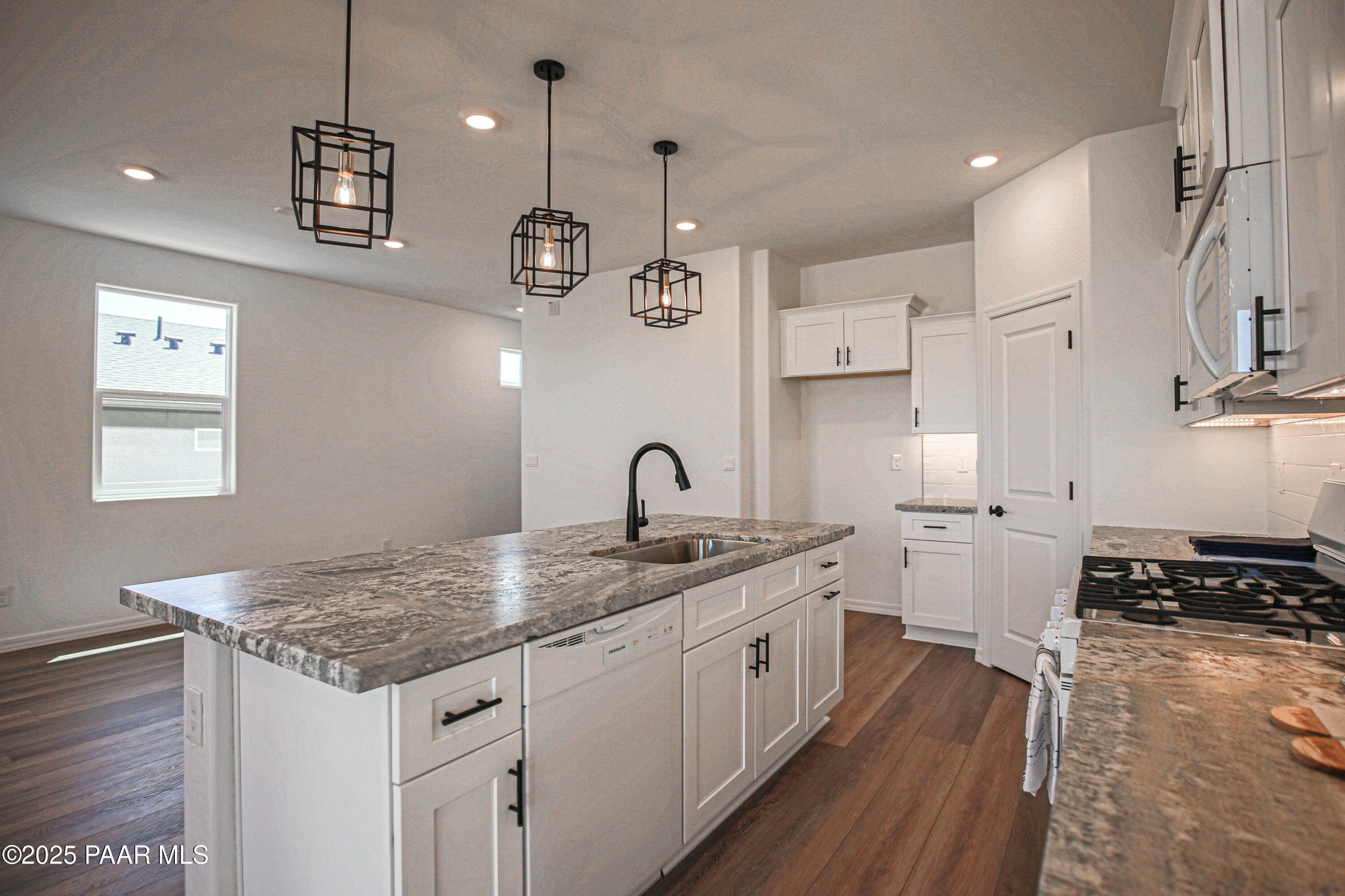 1224 Woodchute Road Prescott, AZ 86305 - Photo 10 of 43 a kitchen with a sink dishwasher and white cabinets with wooden floor