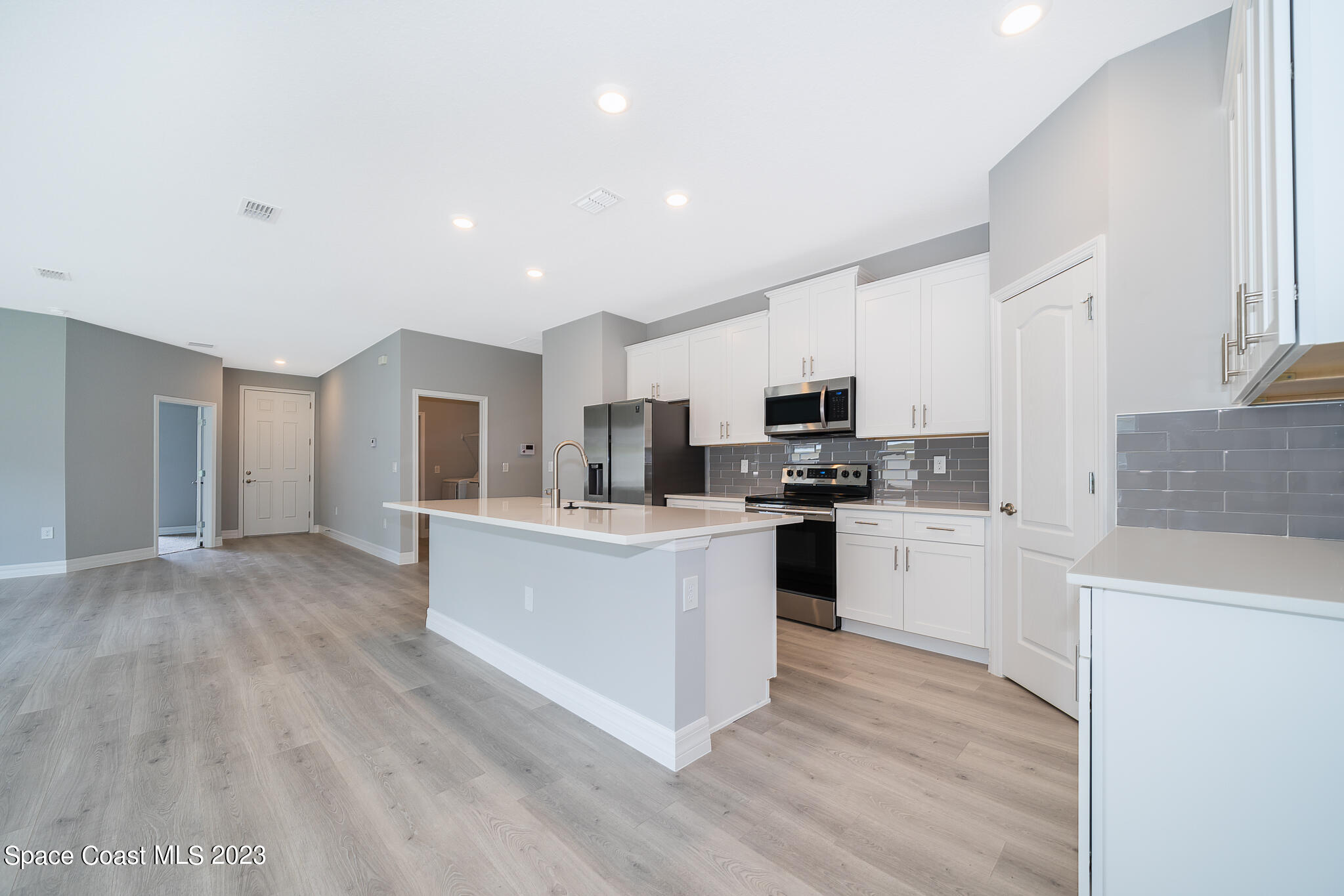 209 Tatum Road Southwest Palm Bay, FL 32908 - Photo 11 of 27 a kitchen with white cabinets and stainless steel appliances