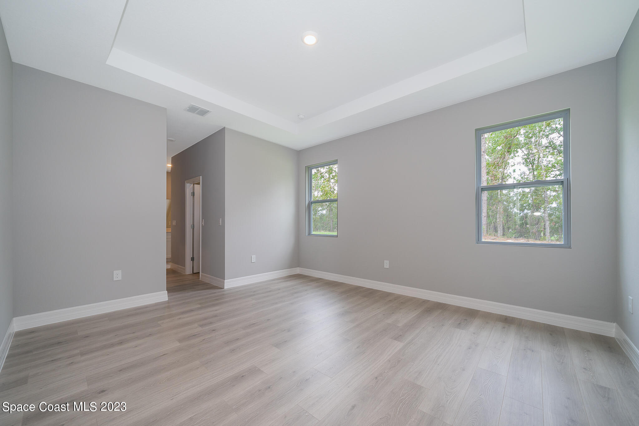 209 Tatum Road Southwest Palm Bay, FL 32908 - Photo 15 of 27 an empty room with wooden floor and windows