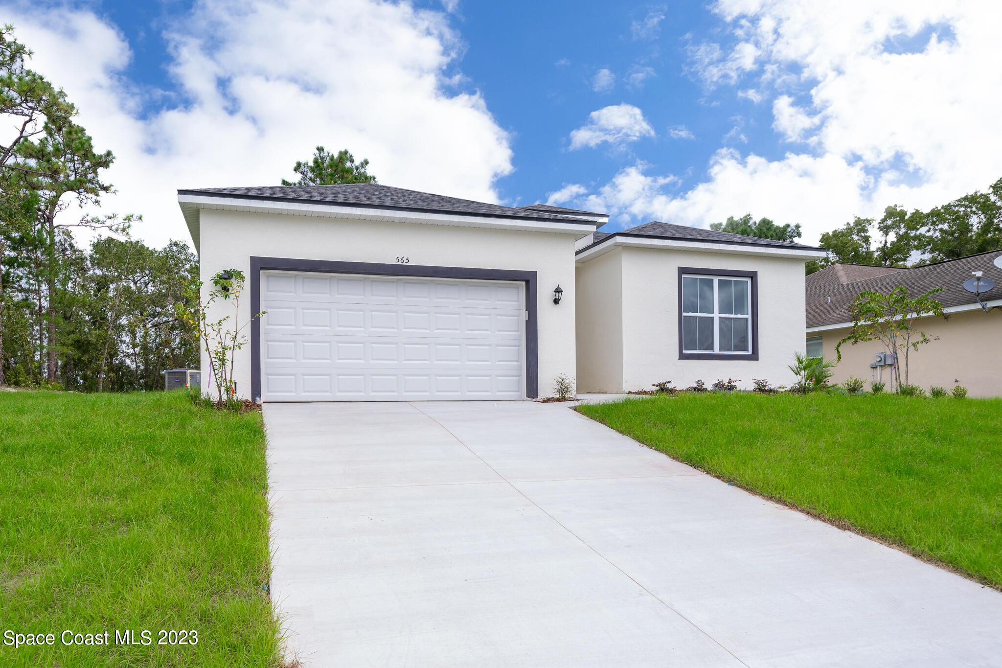 209 Tatum Road Southwest Palm Bay, FL 32908 - Photo 2 of 27 a front view of house with yard and trees in the background