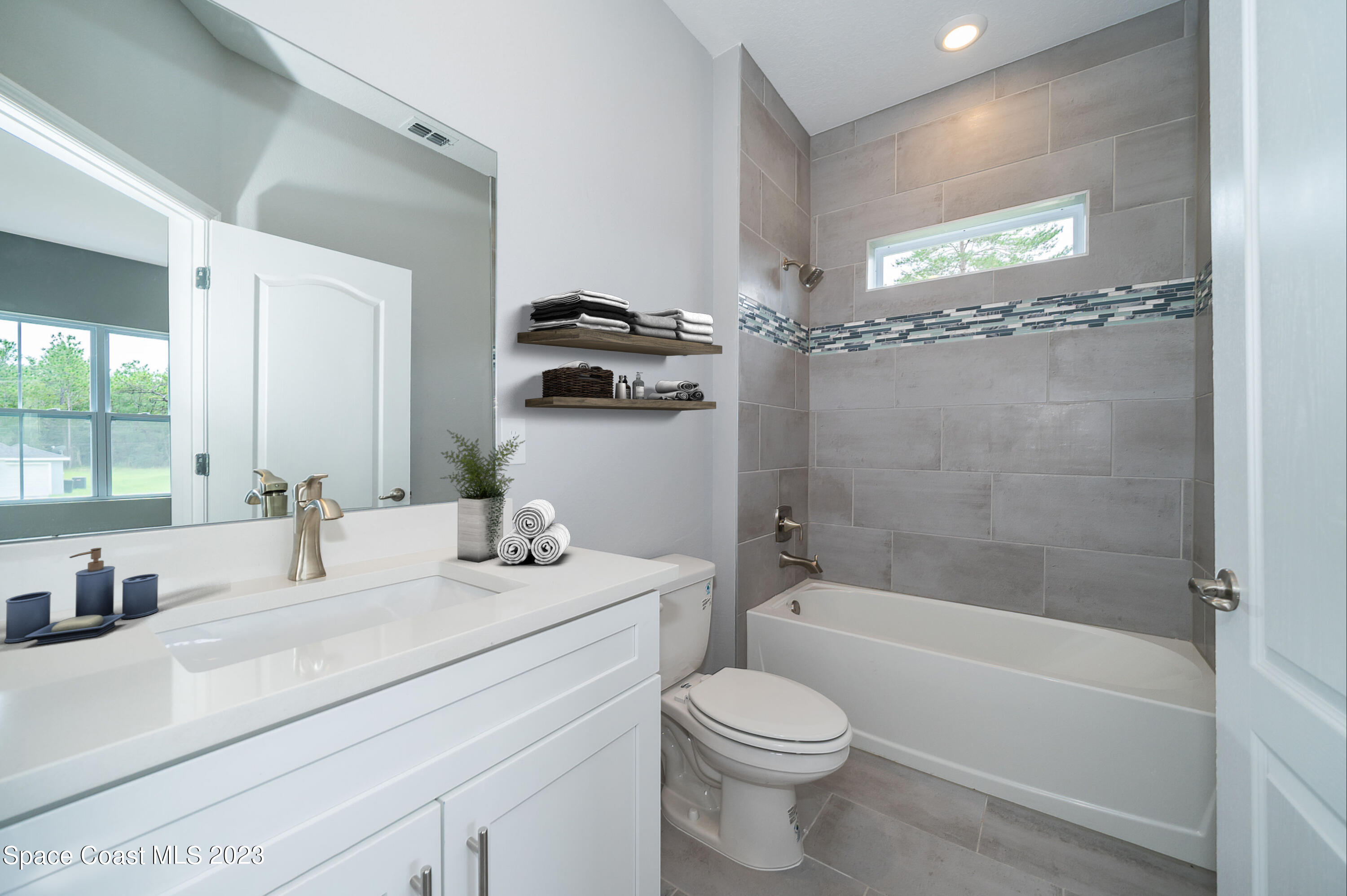 209 Tatum Road Southwest Palm Bay, FL 32908 - Photo 21 of 27 a bathroom with a bathtub shower sink vanity and toilet