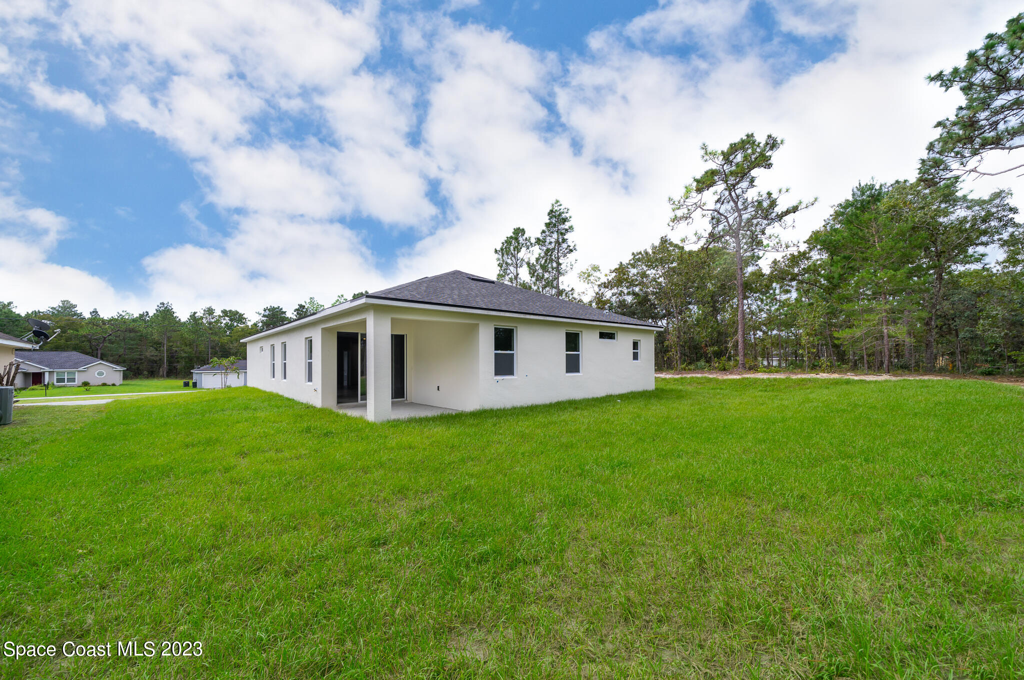 209 Tatum Road Southwest Palm Bay, FL 32908 - Photo 27 of 27 a view of a house with a big yard potted plants and large tree