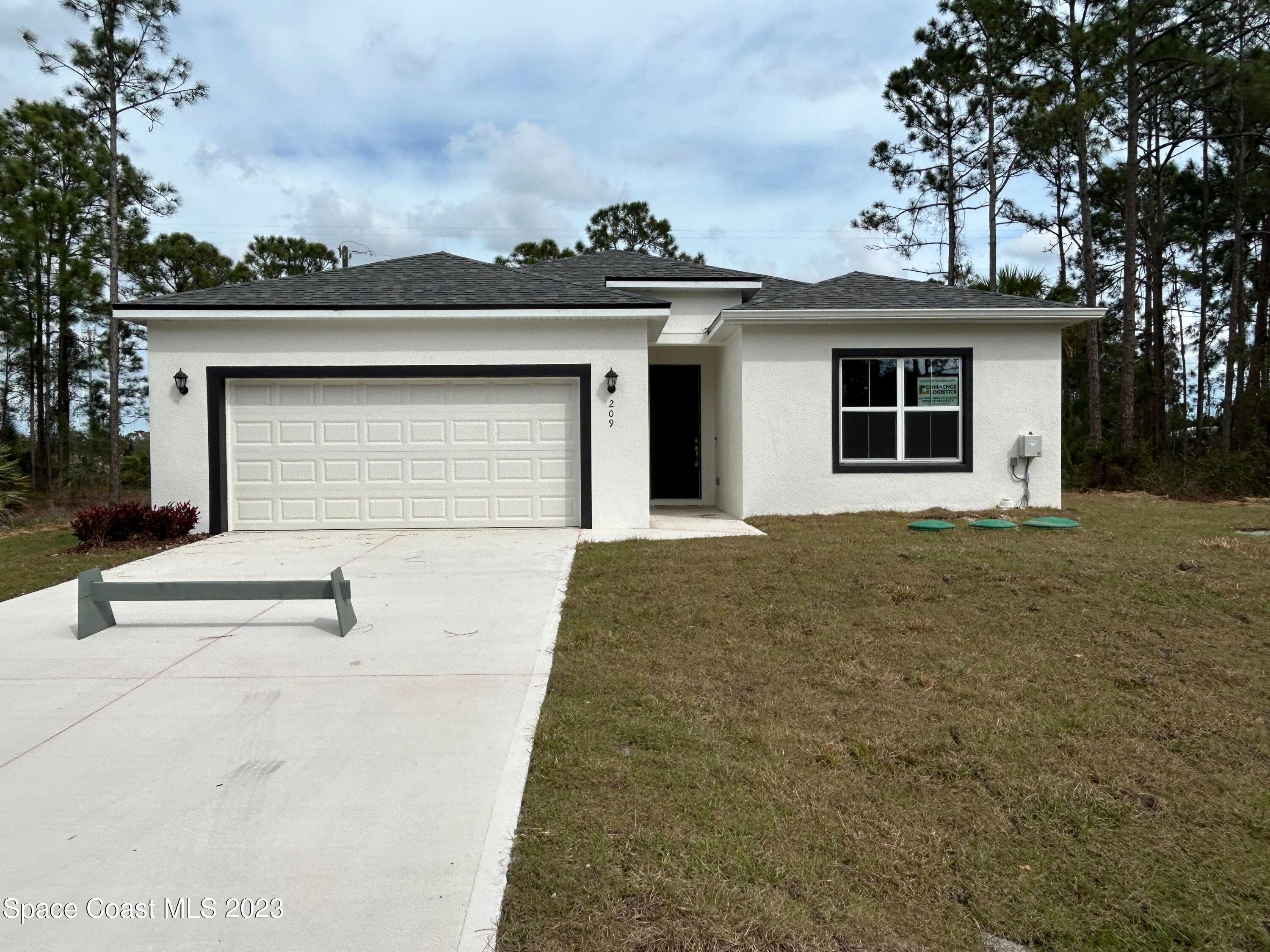 209 Tatum Road Southwest Palm Bay, FL 32908 - Photo 4 of 27 front view of a house with a garage
