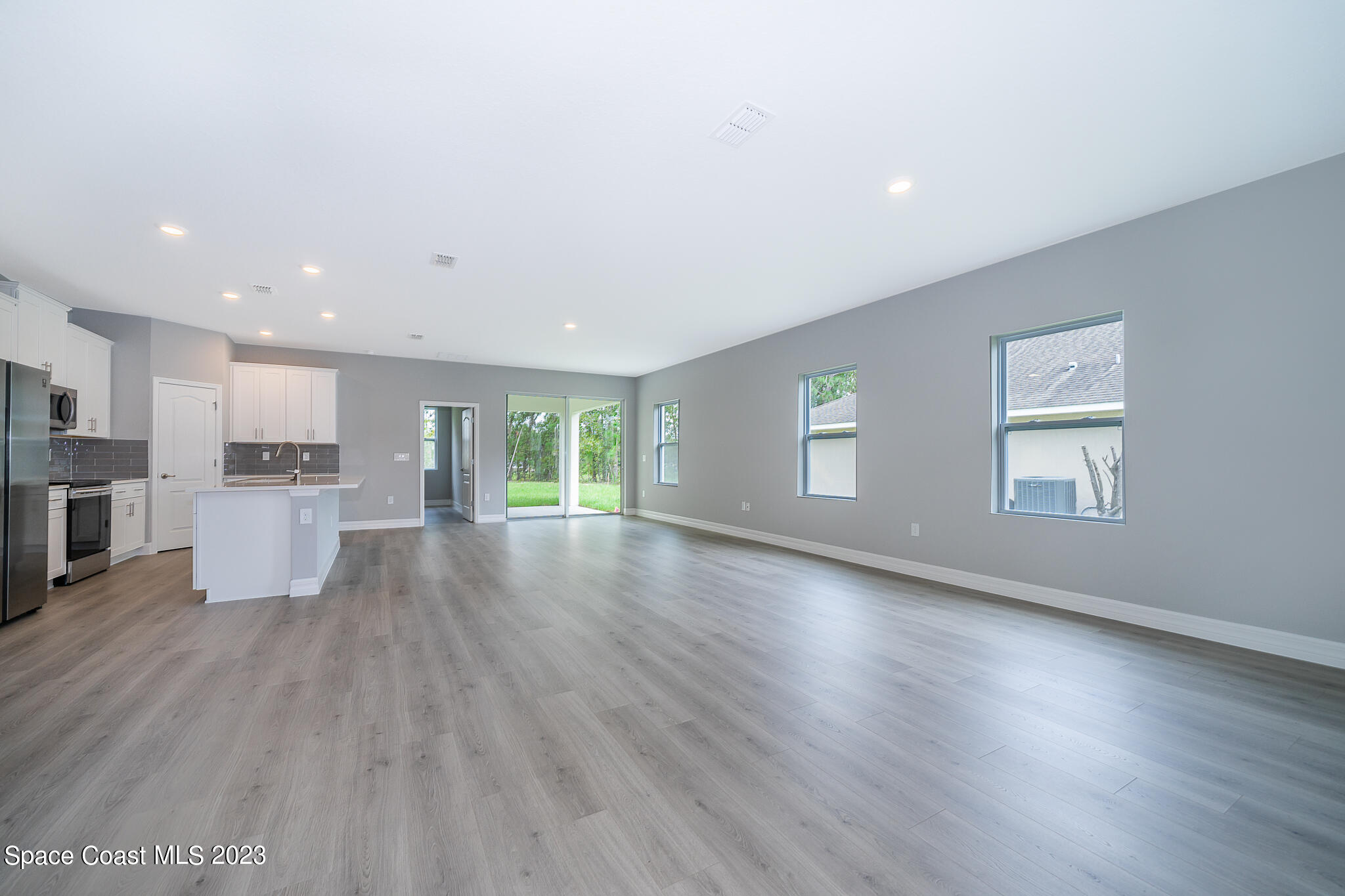 209 Tatum Road Southwest Palm Bay, FL 32908 - Photo 5 of 27 a view of empty room with wooden floor and kitchen