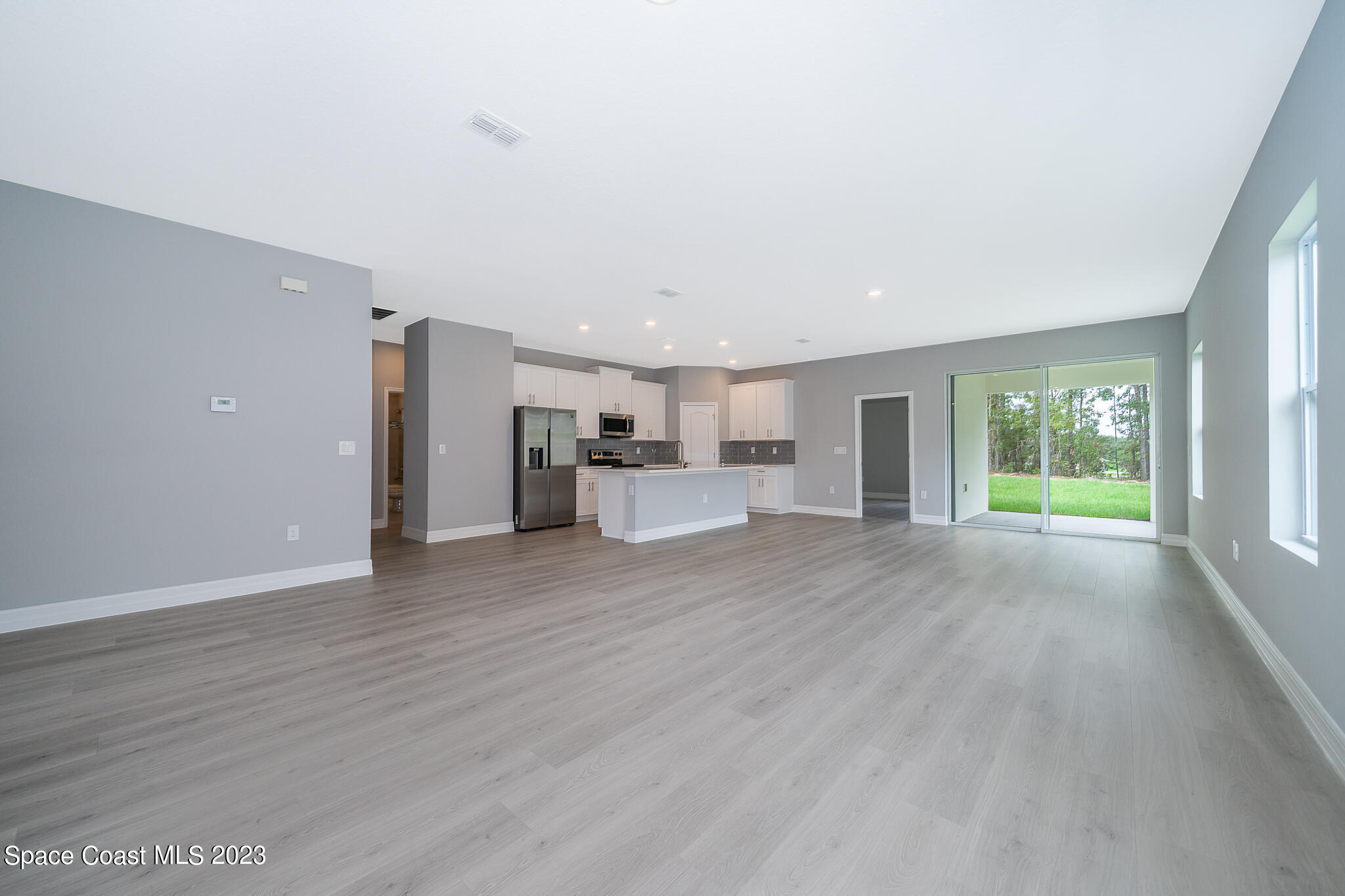 209 Tatum Road Southwest Palm Bay, FL 32908 - Photo 6 of 27 a view of empty room with wooden floor and fan