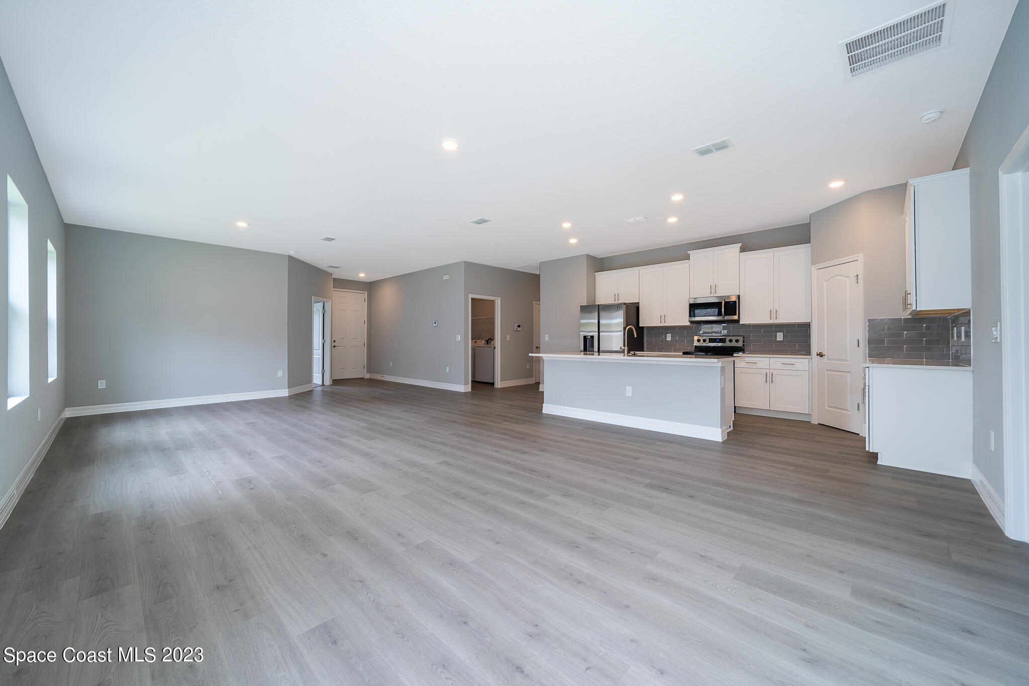 209 Tatum Road Southwest Palm Bay, FL 32908 - Photo 9 of 27 a view of kitchen with wooden floor and electronic appliances