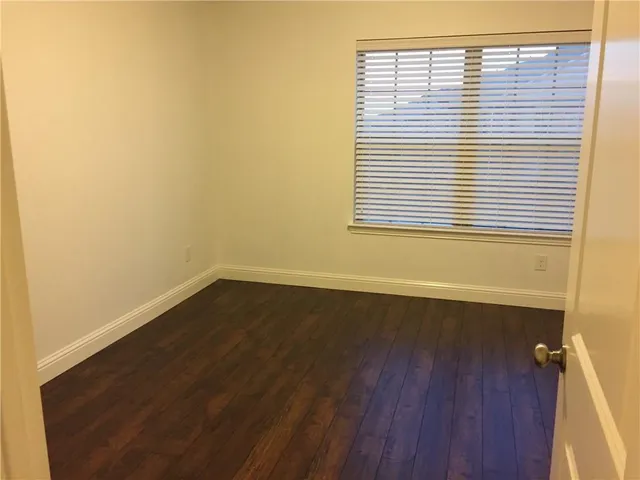 an empty room with wooden floor and a window