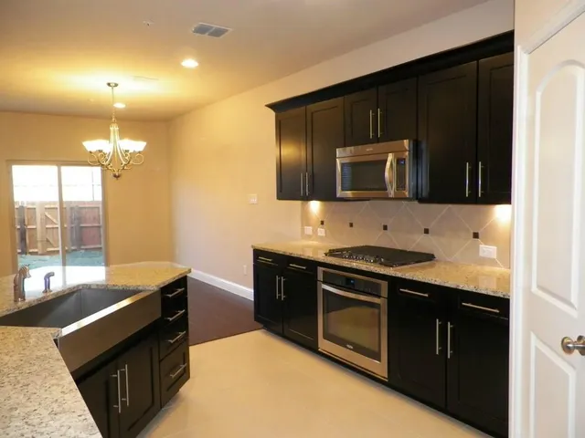 a kitchen with stainless steel appliances wooden cabinets and a stove top oven