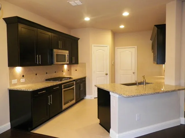 a kitchen with stainless steel appliances granite countertop a sink and a stove