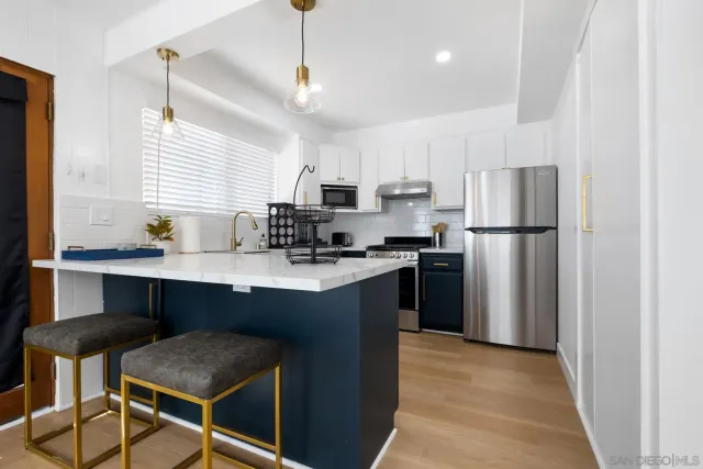 a kitchen with kitchen island a refrigerator stove and microwave
