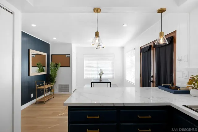 a room with kitchen island a sink and wooden floor