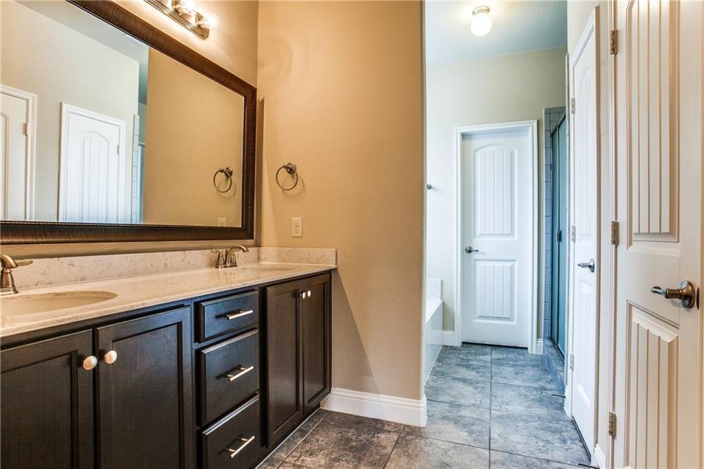300 Rugby Lane McKinney, TX 75072 - Photo 12 of 25 Dual vanity with dark wood-finish cabinetry, light-toned countertop, and undermount sinks