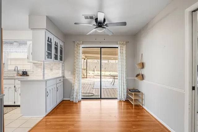a hallway with white cabinets and wooden floor