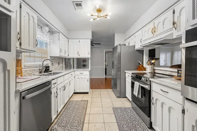 a kitchen with stainless steel appliances granite countertop a stove a sink and a refrigerator