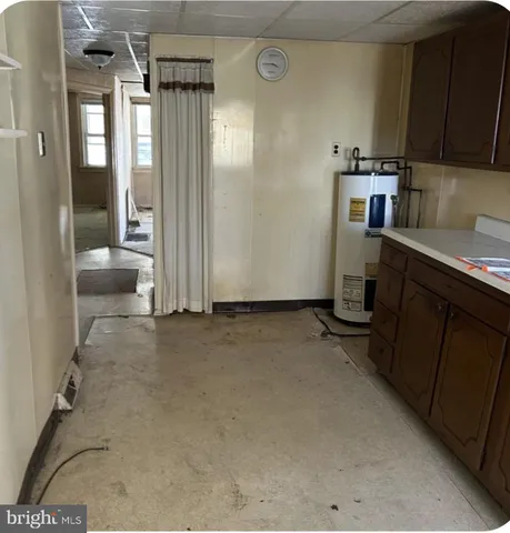 a view of a hallway with wooden floor and a living room