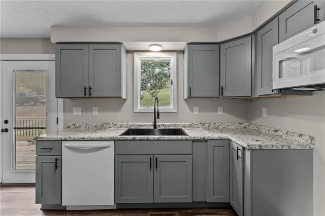 a kitchen with stainless steel appliances granite countertop a sink stove and cabinets