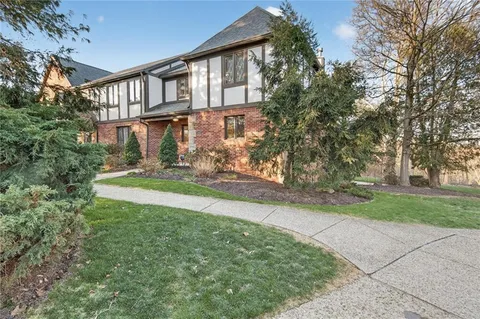 a front view of a house with a yard and trees