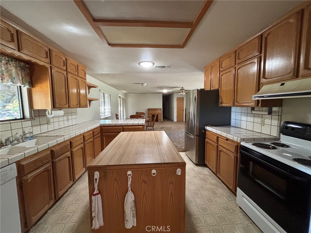 4918 Indian Peak Road Mariposa, CA 95338 - Photo 11 of 39 a kitchen with stainless steel appliances granite countertop a sink a stove and a refrigerator