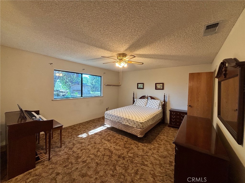 4918 Indian Peak Road Mariposa, CA 95338 - Photo 20 of 39 a bedroom with a bed and dresser with wooden floor