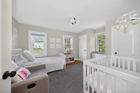 a spacious bedroom with a bed and wooden floor