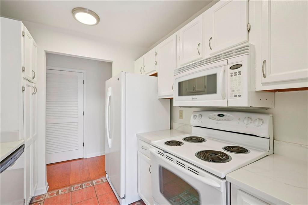 1750 Clairmont Road, Unit 21 Decatur, GA 30033 - Photo 9 of 23 a kitchen with white cabinets and white appliances