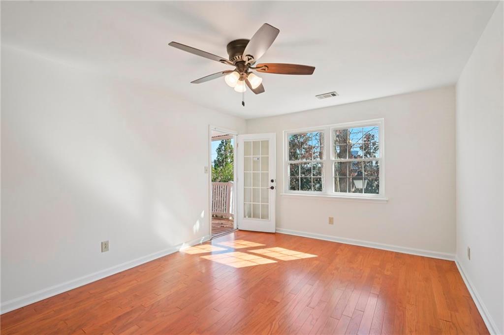 1750 Clairmont Road, Unit 21 Decatur, GA 30033 - Photo 10 of 23 an empty room with wooden floor chandelier fan and windows