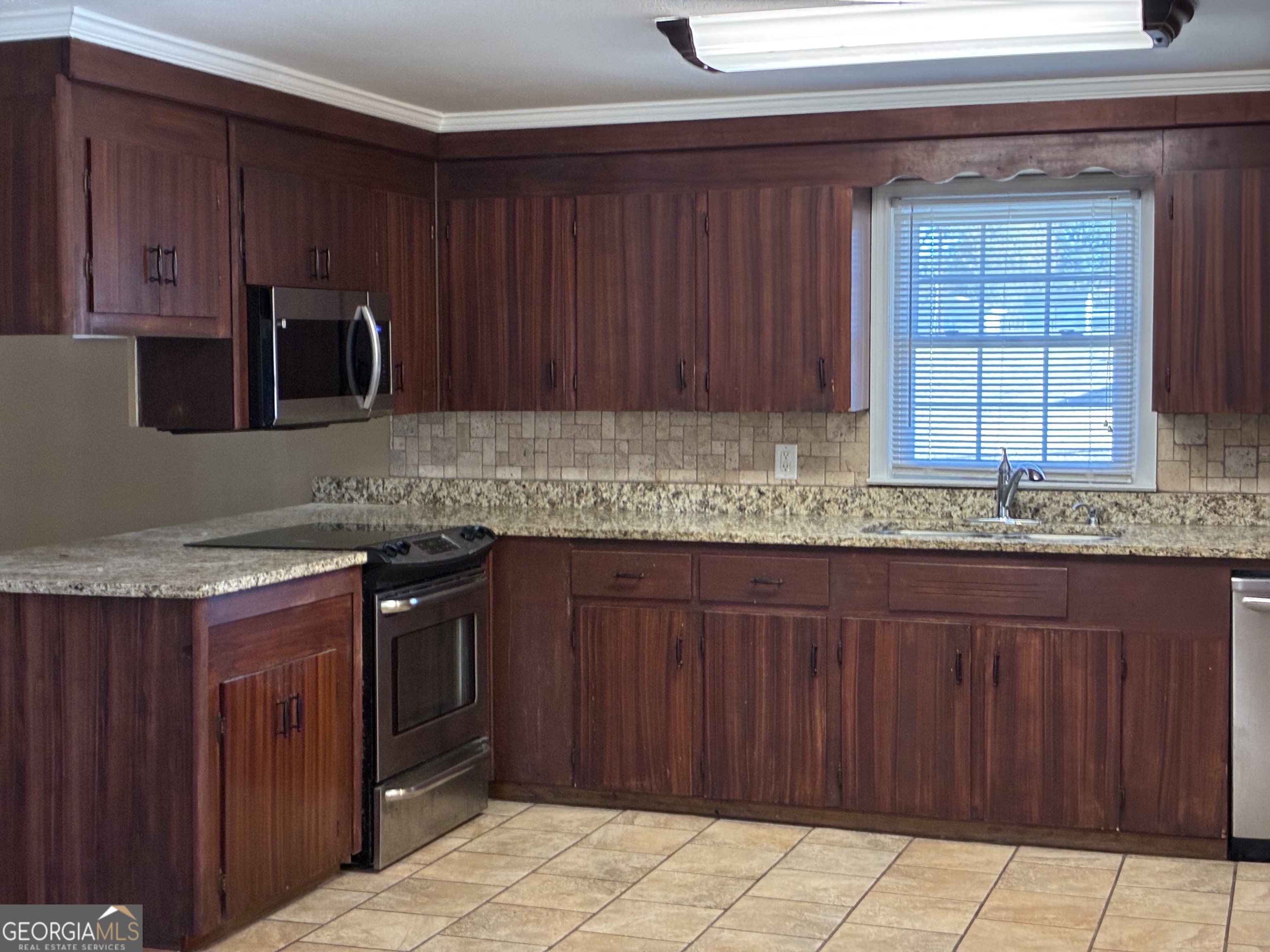 3491 Sandy Circle Macon, GA 31216 - Photo 13 of 49 a kitchen with granite countertop wooden cabinets a granite counter and a sink