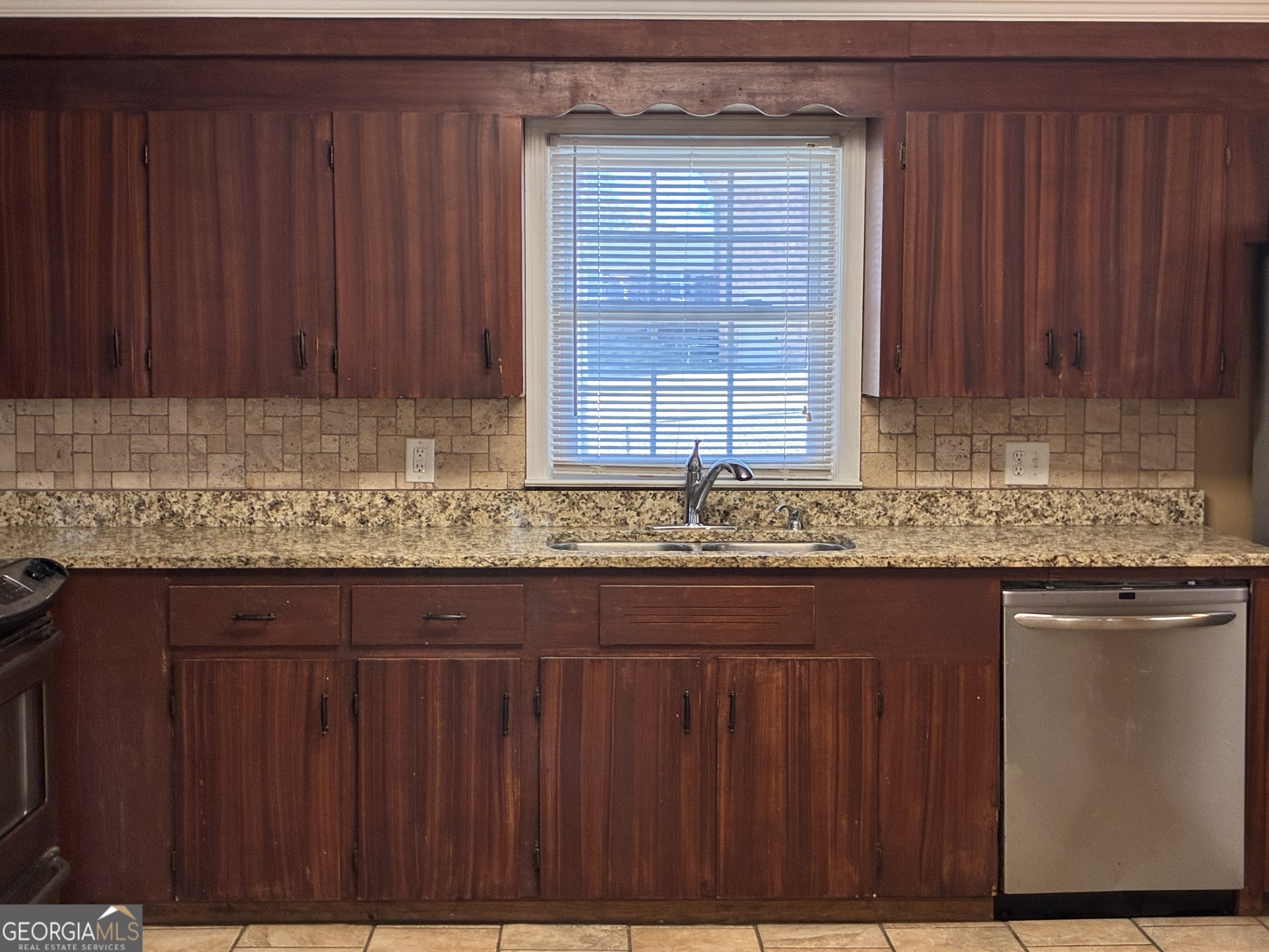 3491 Sandy Circle Macon, GA 31216 - Photo 10 of 49 a kitchen with granite countertop wooden cabinets a sink and a counter top
