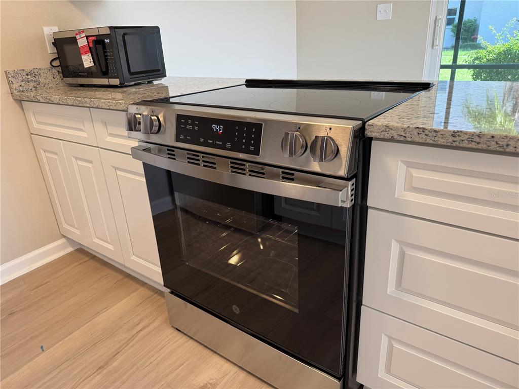 5521 Bay Boulevard, Unit 105 Port Richey, FL 34668 - Photo 6 of 15 a close view of stove and microwave