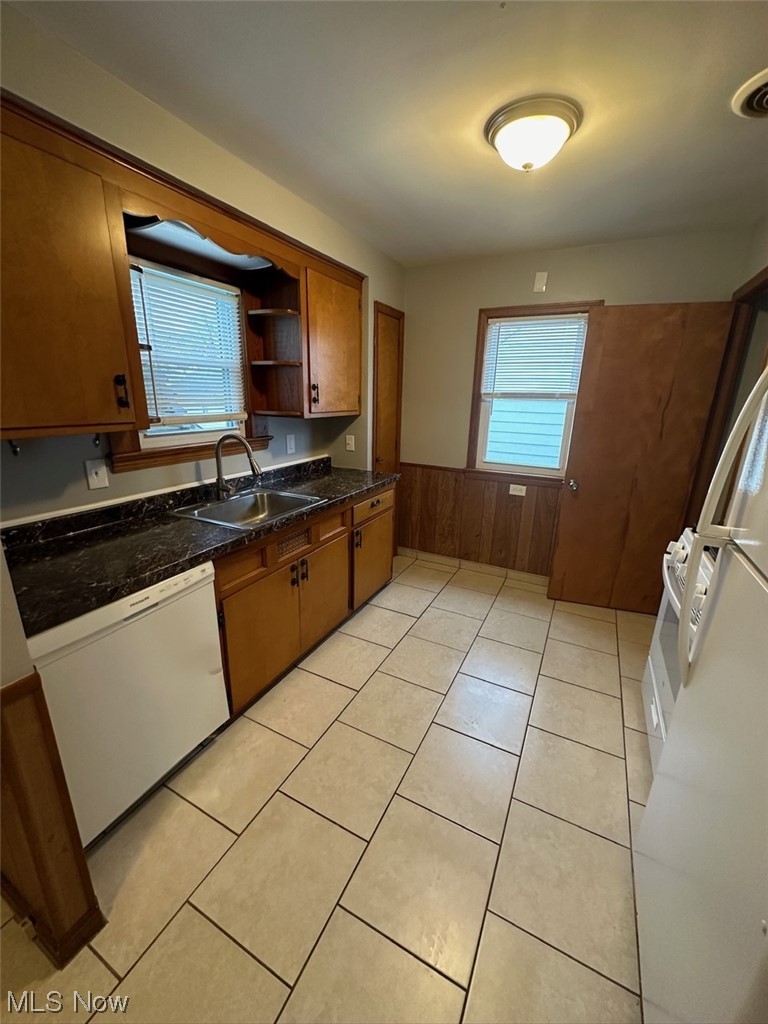 4994 North Barton Road Cleveland, OH 44124 - Photo 7 of 28 Kitchen with sink, dark stone countertops, dishwasher, and light tile floors