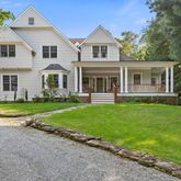 a front view of a house with a yard and trees