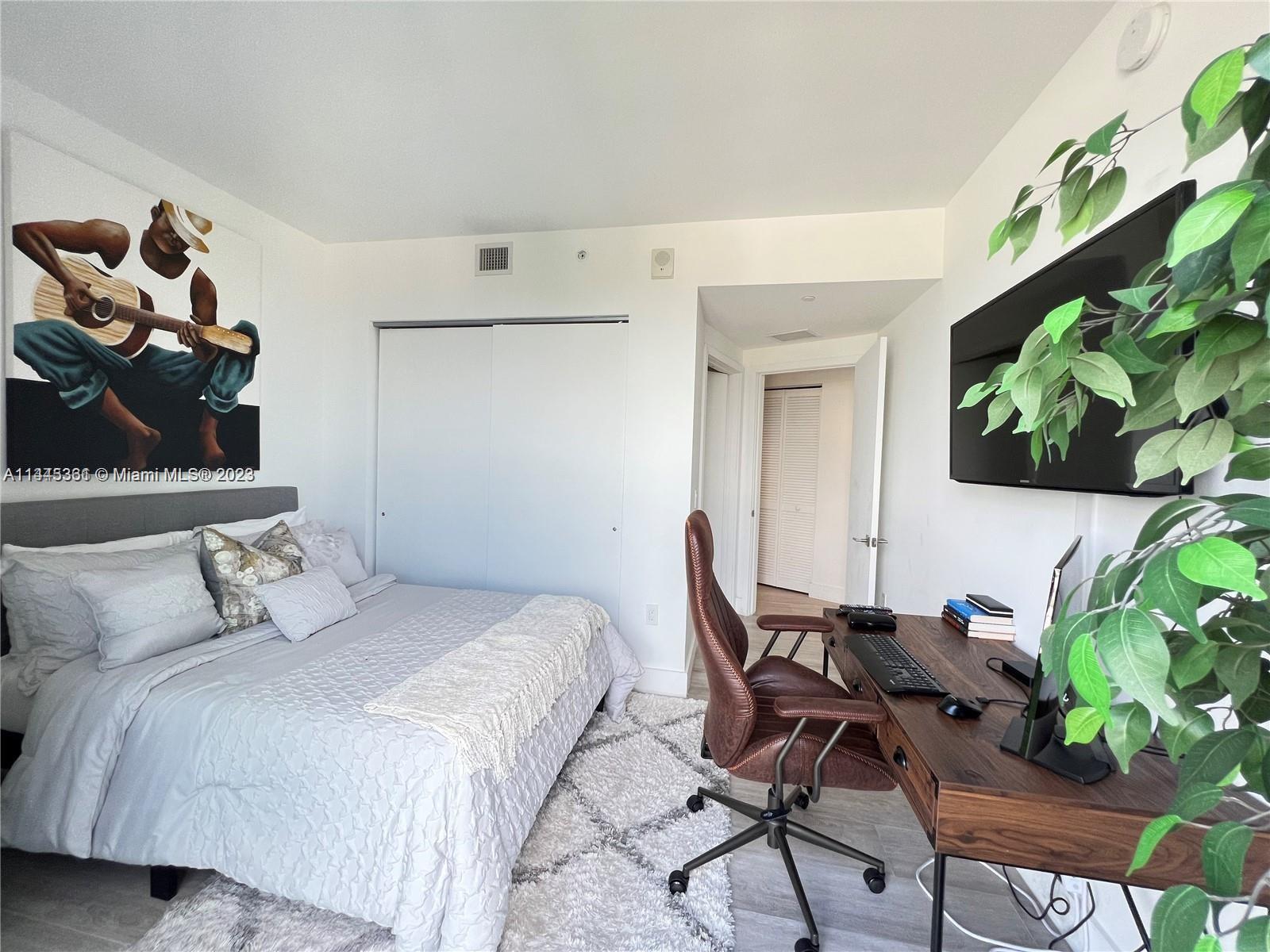 Midtown Miami Miami, FL 33137 - Photo 11 of 14 a bedroom with a bed and a potted plant