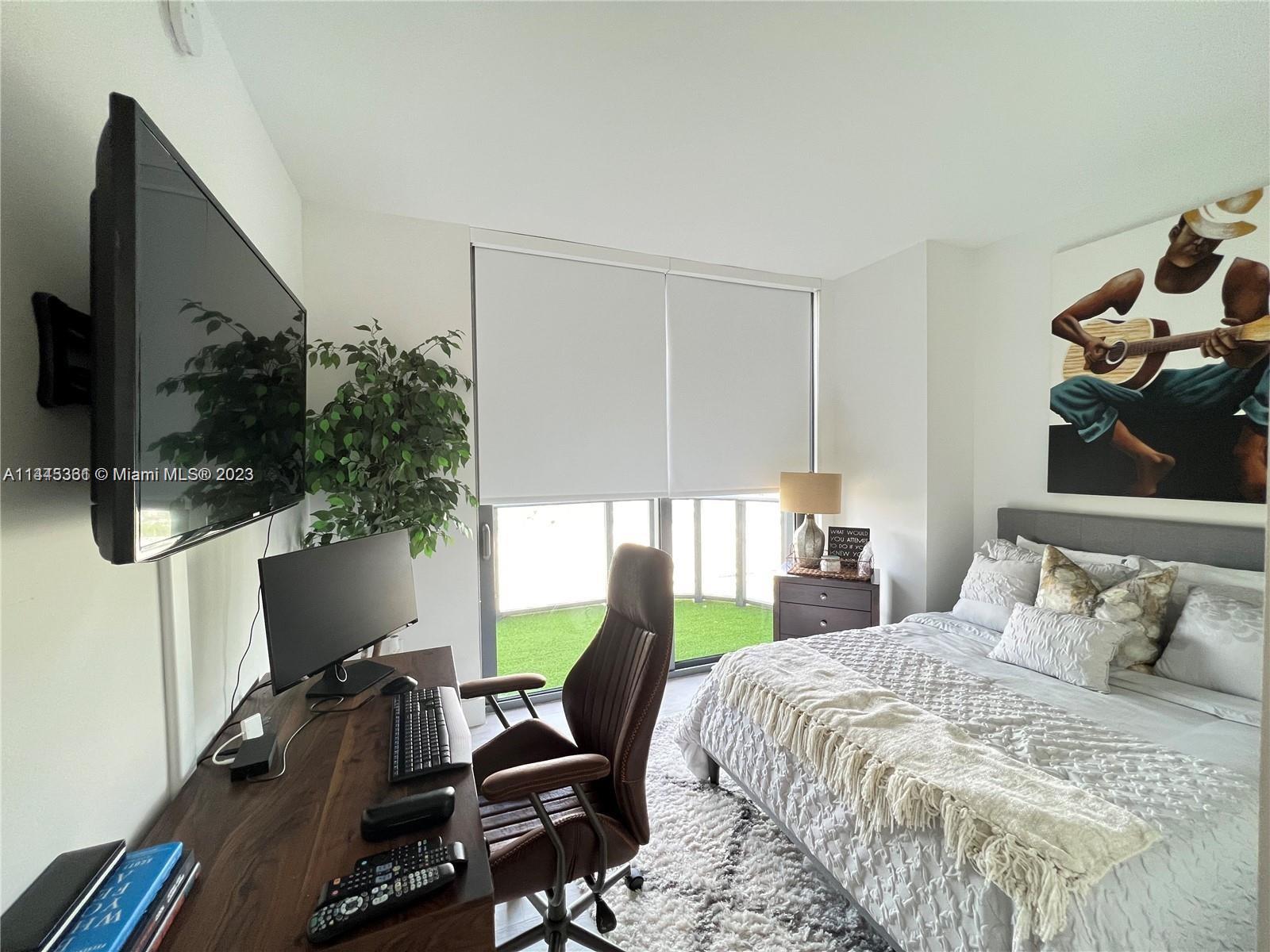 Midtown Miami Miami, FL 33137 - Photo 12 of 14 a bedroom with a bed a flat screen tv and next to a window