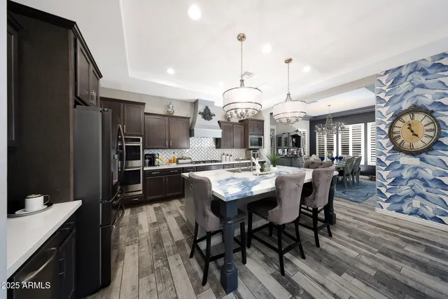 a kitchen with stainless steel appliances kitchen island granite countertop a sink a stove and a refrigerator