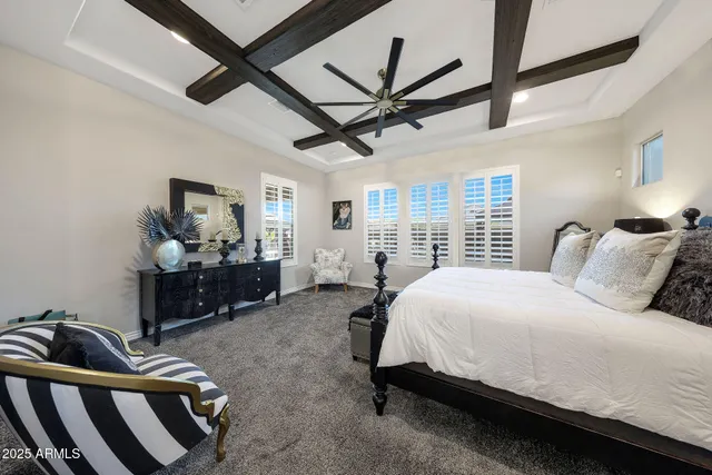 a spacious bedroom with a bed a couch and a large window