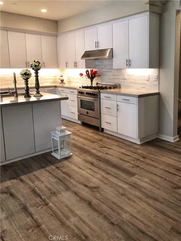 a kitchen with stainless steel appliances granite countertop a sink stove and cabinets