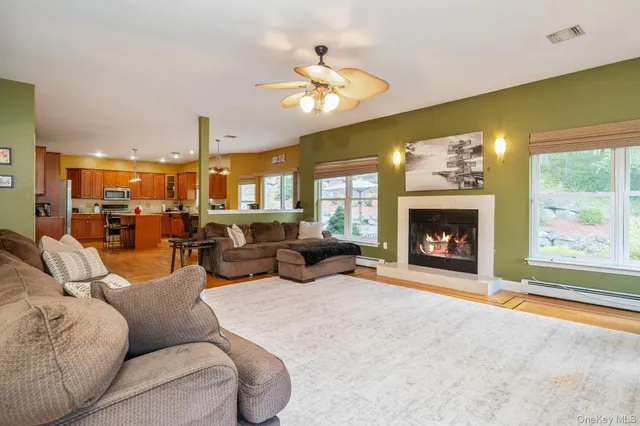 a living room with furniture a fireplace and a large window