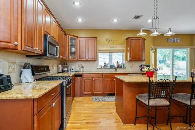 a kitchen with stainless steel appliances granite countertop a sink a stove and a refrigerator