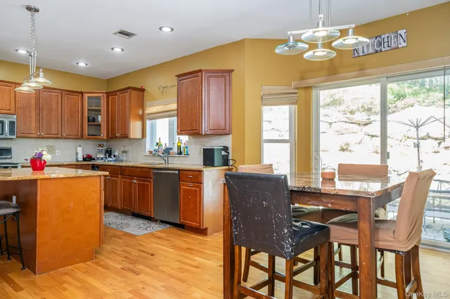 a kitchen with granite countertop wooden cabinets dining table and chairs