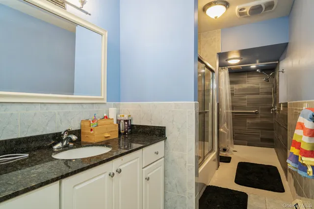 a bathroom with a granite countertop sink and a mirror