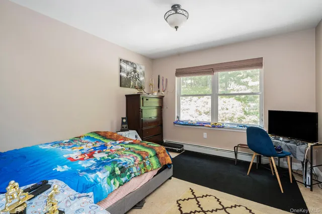 a bedroom with a bed table chair and two windows