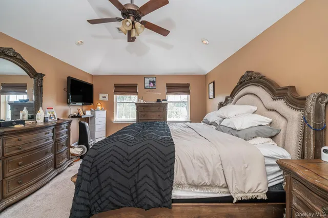 a bedroom with a large bed and flat tv screen