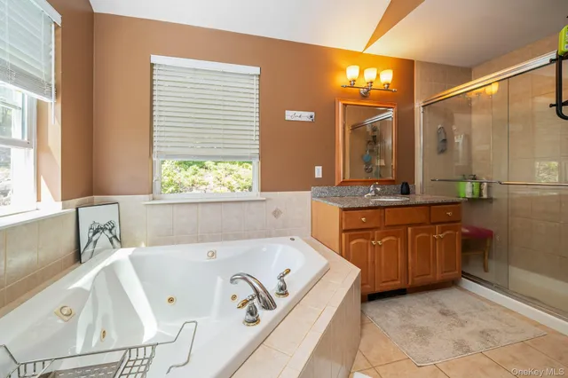a bathroom with a tub sink and mirror