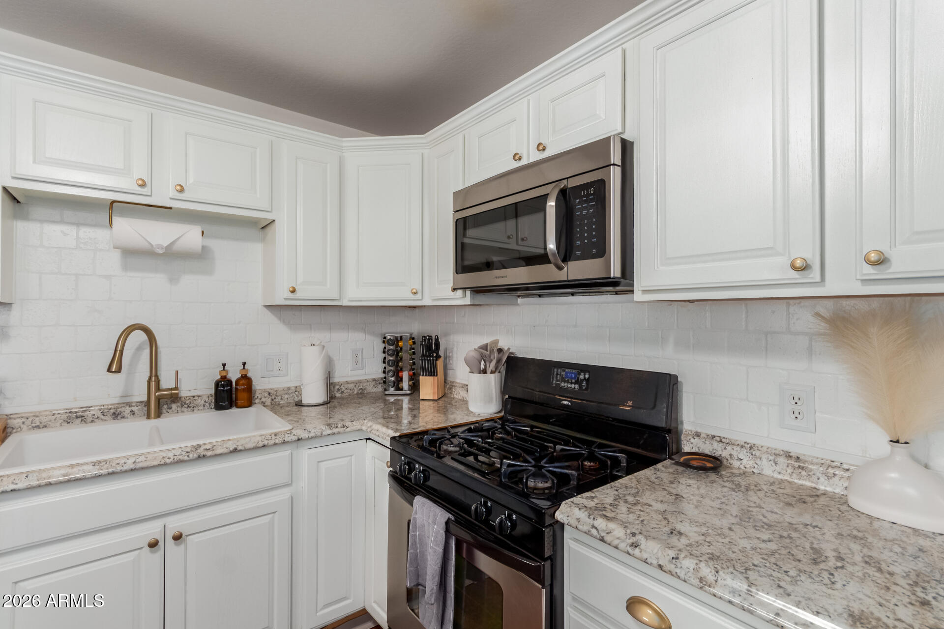 2715 West Royal Palm Road Phoenix, AZ 85051 - Photo 16 of 32 a kitchen with granite countertop white cabinets stainless steel appliances and sink