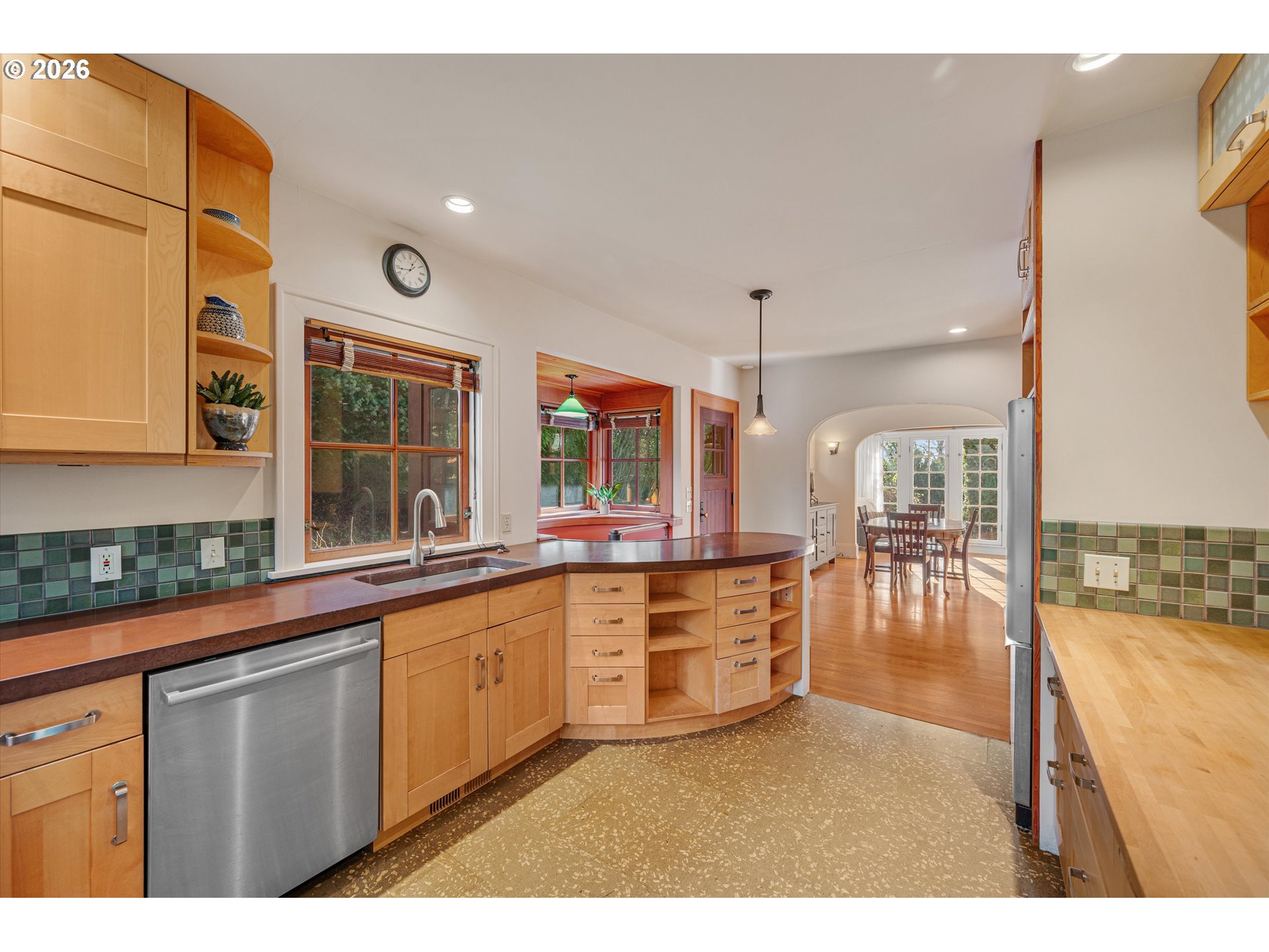 2783 Northeast Wiberg Lane Portland, OR 97213 - Photo 21 of 48 a open kitchen with granite countertop a stove a sink a dining table and chairs with wooden floor