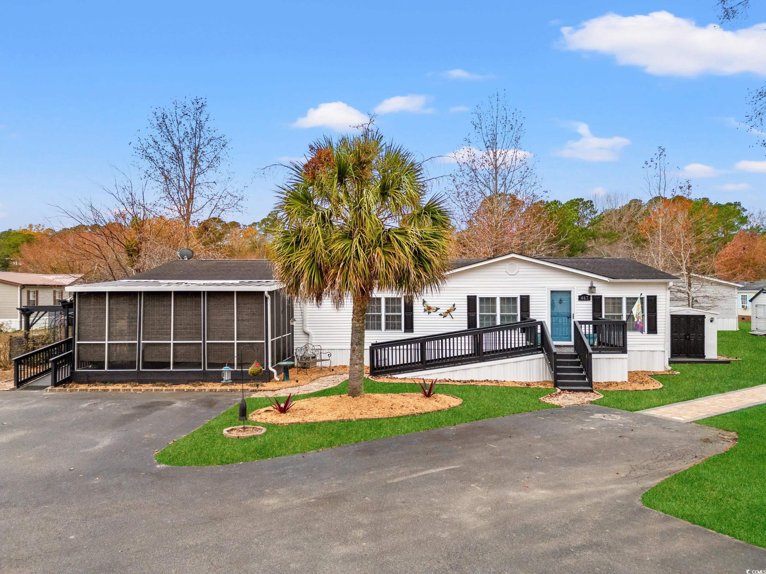 Manufactured / mobile home featuring a front yard and a wooden deck