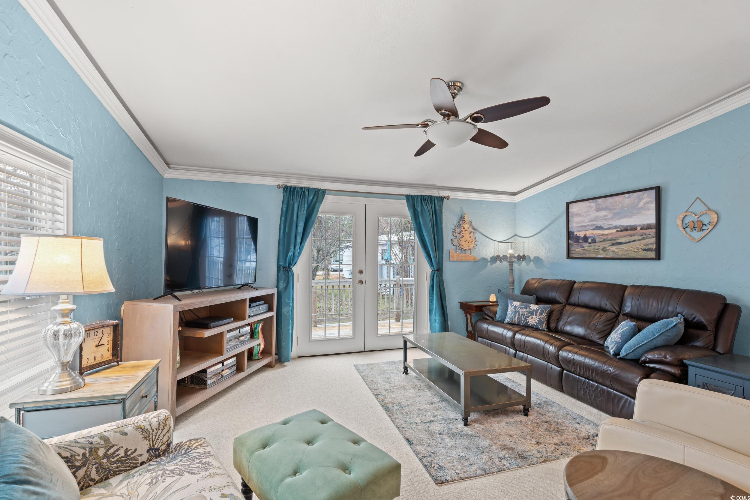 467 Freedom Circle Myrtle Beach, SC 29588 - Photo 16 of 38 Carpeted living room featuring french doors, a textured wall, ornamental molding, and ceiling fan