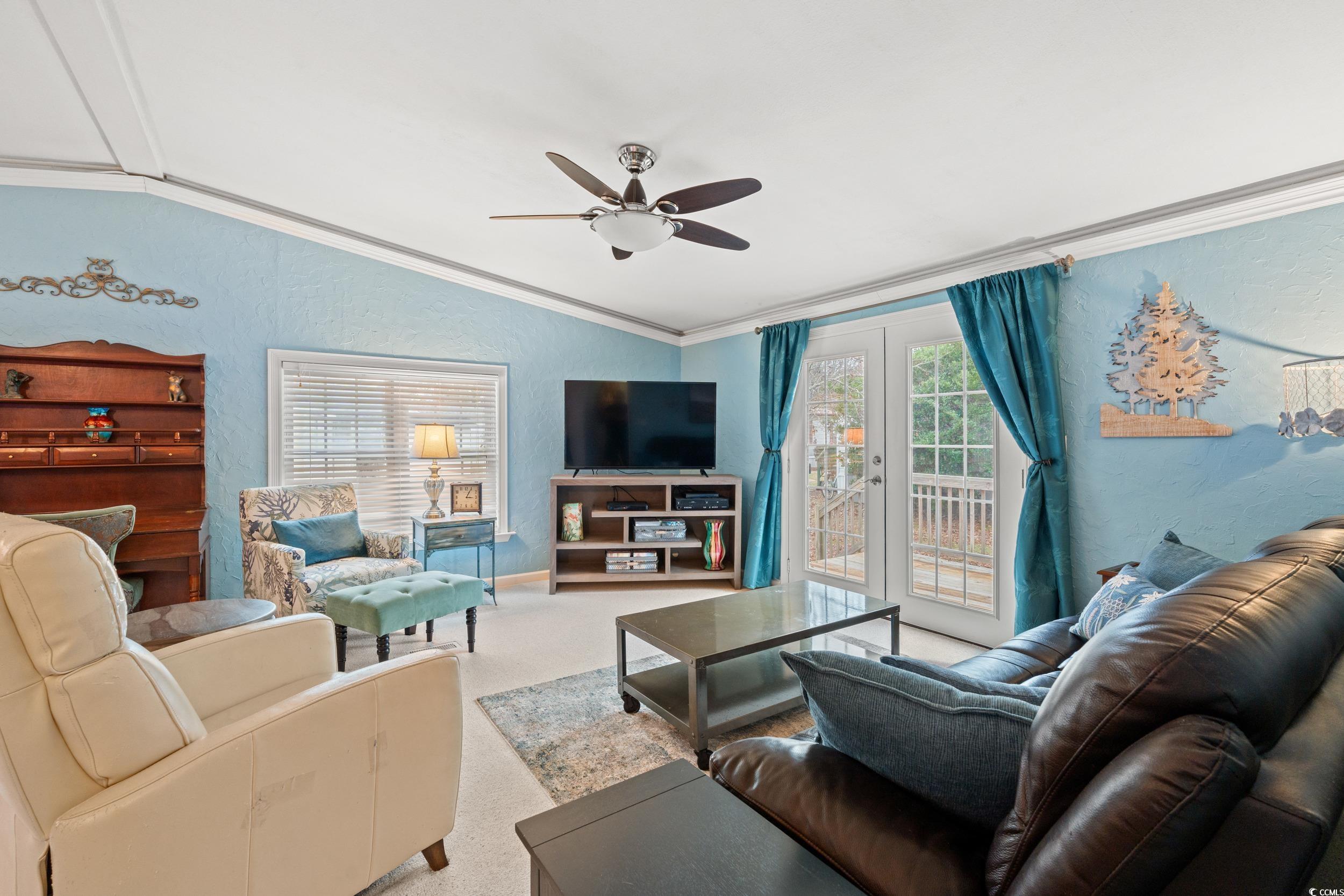 467 Freedom Circle Myrtle Beach, SC 29588 - Photo 17 of 38 Living area with a textured wall, french doors, vaulted ceiling, ornamental molding, and a ceiling fan