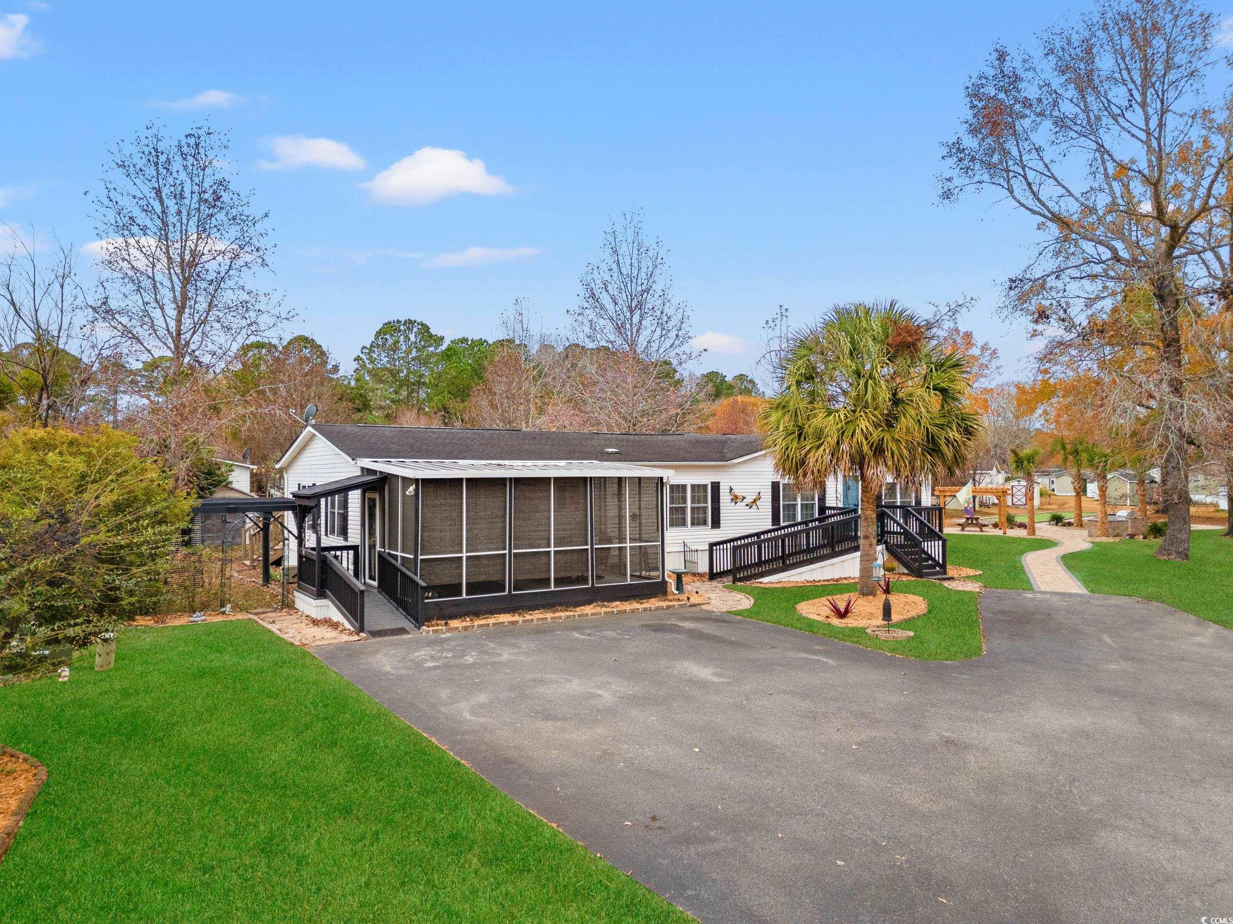 467 Freedom Circle Myrtle Beach, SC 29588 - Photo 2 of 38 View of front of property with a front yard, a sunroom, and asphalt driveway